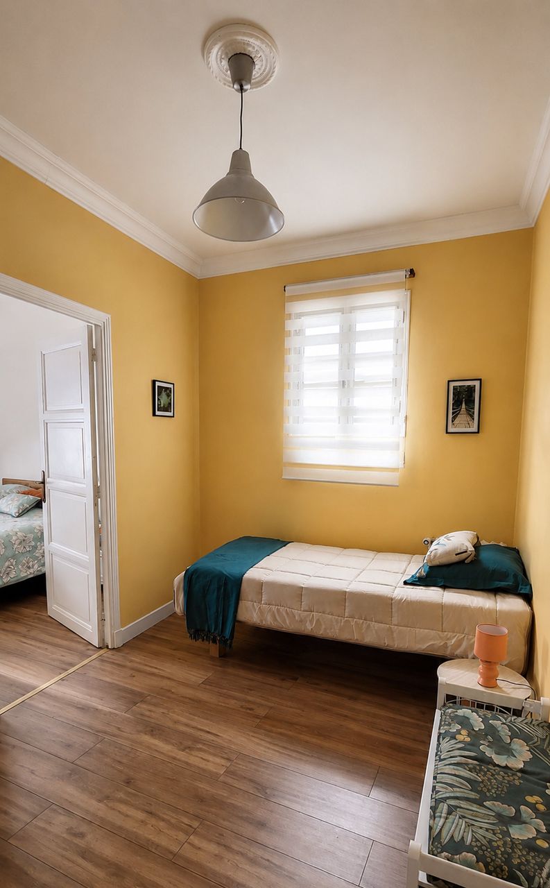 Chambre aux murs jaunes avec lits simples