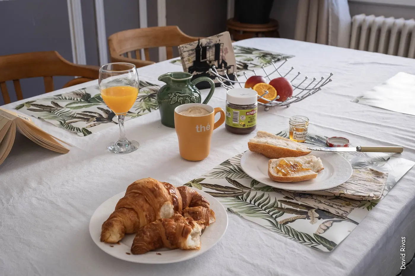 Petit-déjeuner servi : croissants, jus d'orange, confiture et café sur la table