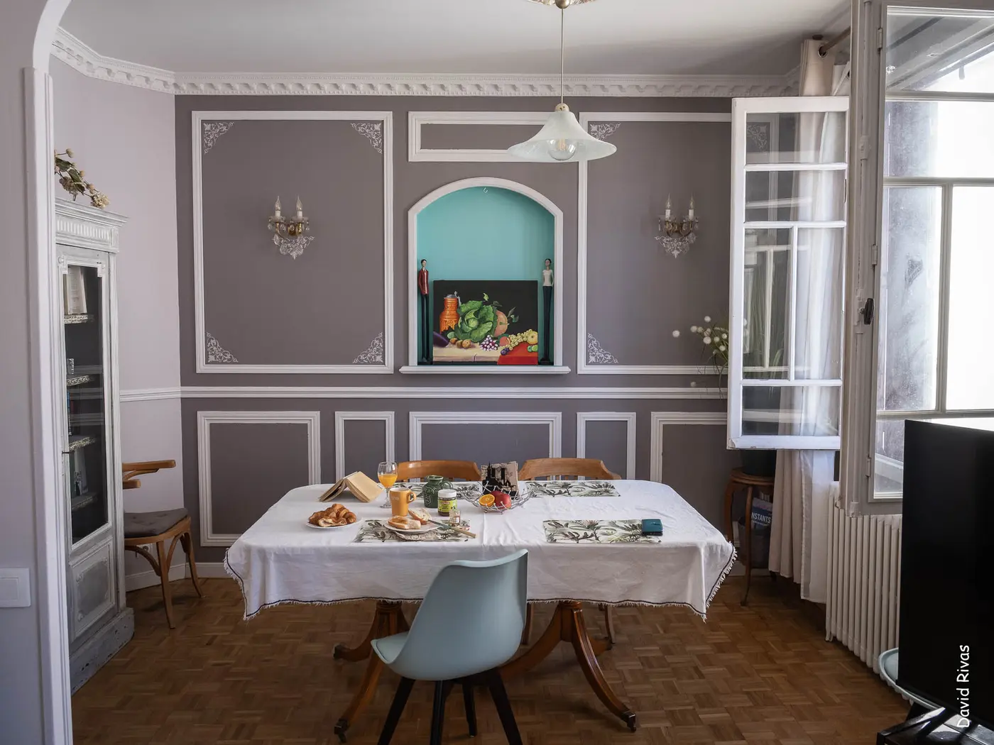 La salle à manger : moulures, niche turquoise et table dressée pour le petit-déjeuner