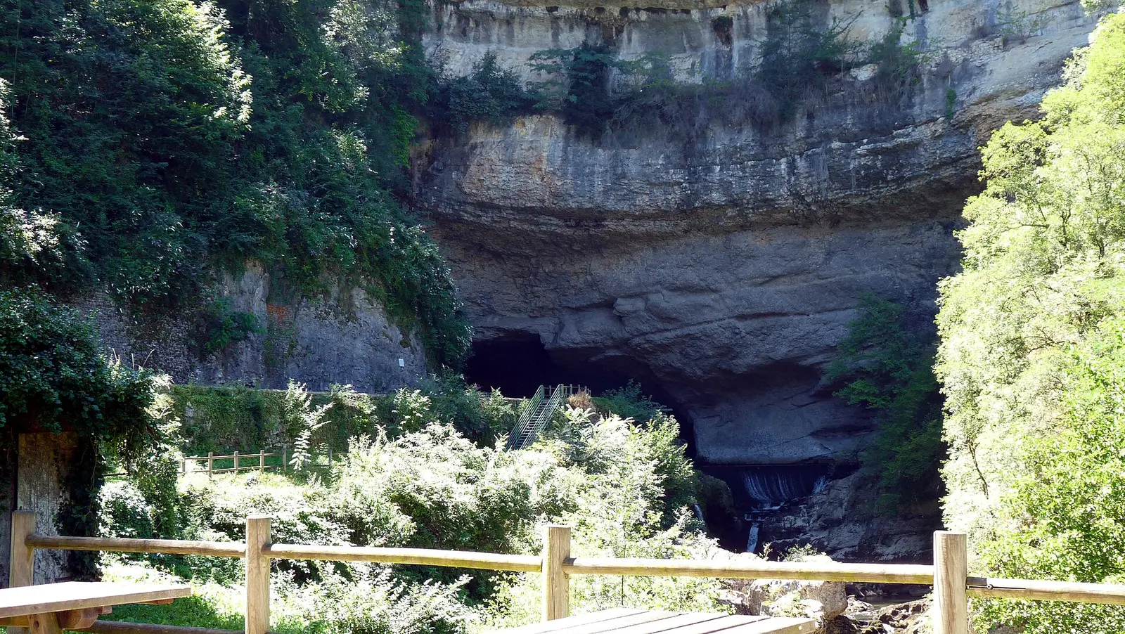 L'entrée nord de la grotte du Mas-d'Azil entourée de végétation